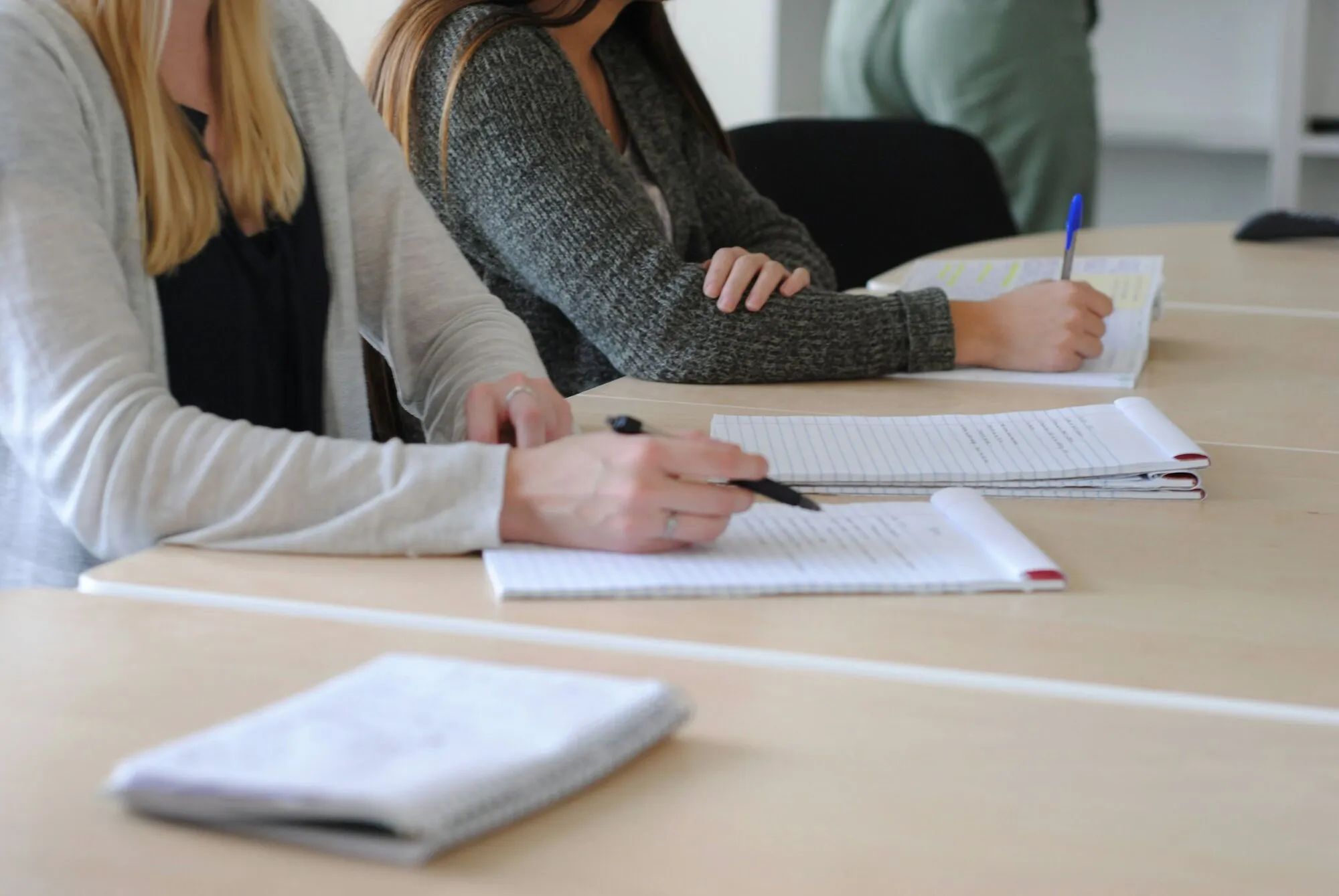 A student taking notes at a desk