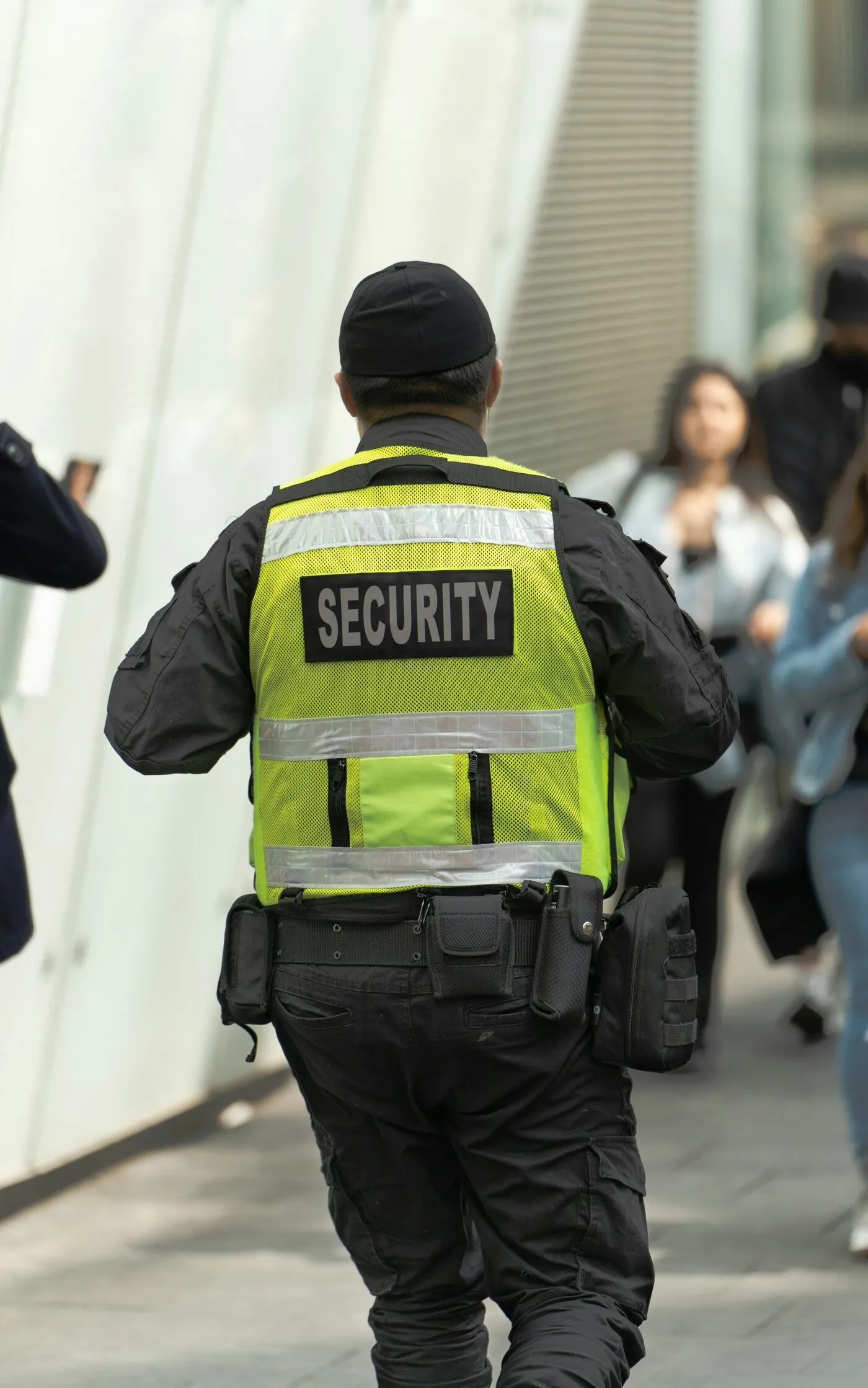 A guard in a reflective SECURITY vest watching a crowd